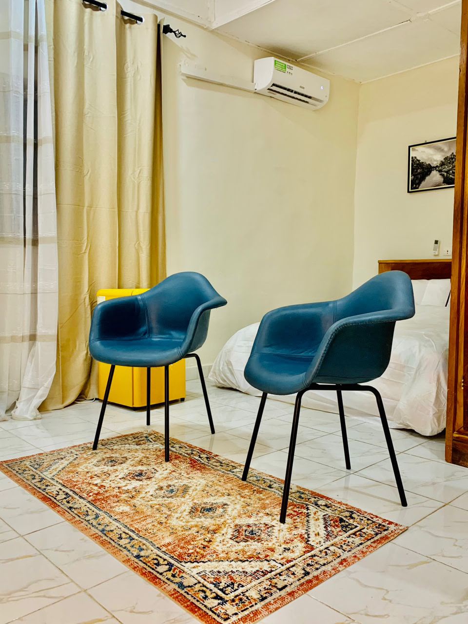 Chambre avec deux fauteuils bleus et un tapis