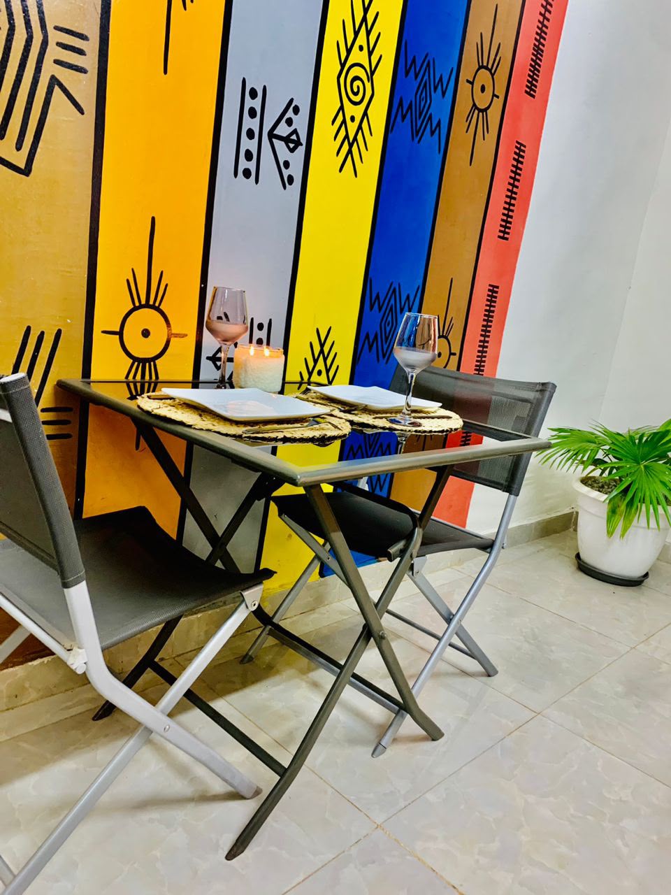 Coin repas avec un mur peint de motifs colorés